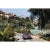 Il Pellicano Tennis 1973 An Aston Martin DB6 sports car driving past the tennis courts at Il Pellicano Hotel in Porto...