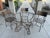 Three vintage wrought iron metal garden dining armchairs, featuring a bronze/gold finish, elegant scroll arms, lattice...