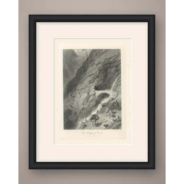A mountain road cuts through a sheer gorge, carried over a rushing torrent on a single stone arch before it disappears...