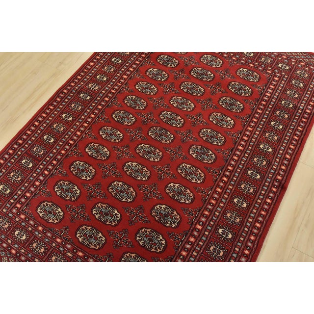 A tribal Bokhara rug hand-knotted with fine wool on a cotton foundation. This rug features rows of repeating medallions...
