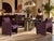 A set of four Postmodern dining armchairs upholstered in a textured purple fabric. Each chair features a channel-detailed...