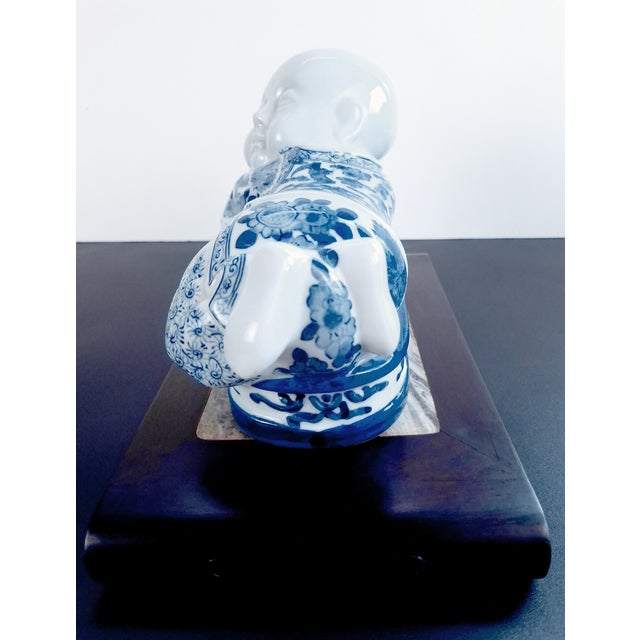 Chinese porcelain pillow, a finely carved, sleeping boy in finely painted blue and white glazes, laying atop a small bed,...