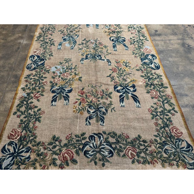 A refined 19th century English needlework tapestry featuring an elegant floral ribbon and bouquet composition, executed...