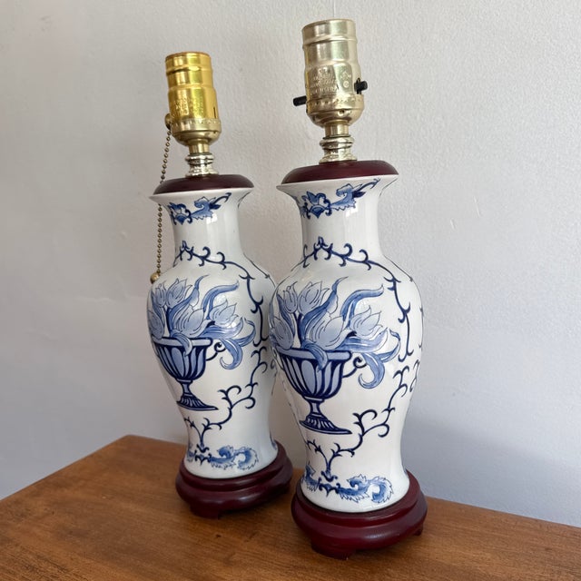 Pretty 1990s blue and white lamp pair with a floral bouquet motif. Wood base and cap. Please see condition details noted....