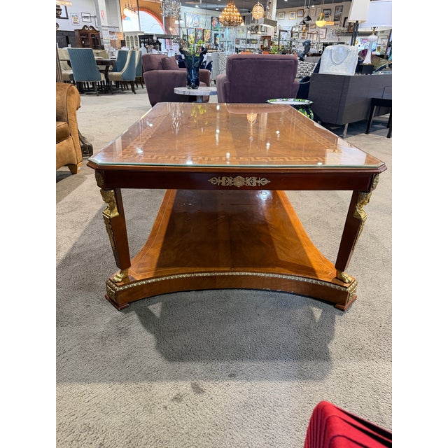 This exquisite Greek key inlay cherry wood coffee table is a refined statement of timeless craftsmanship and classical...