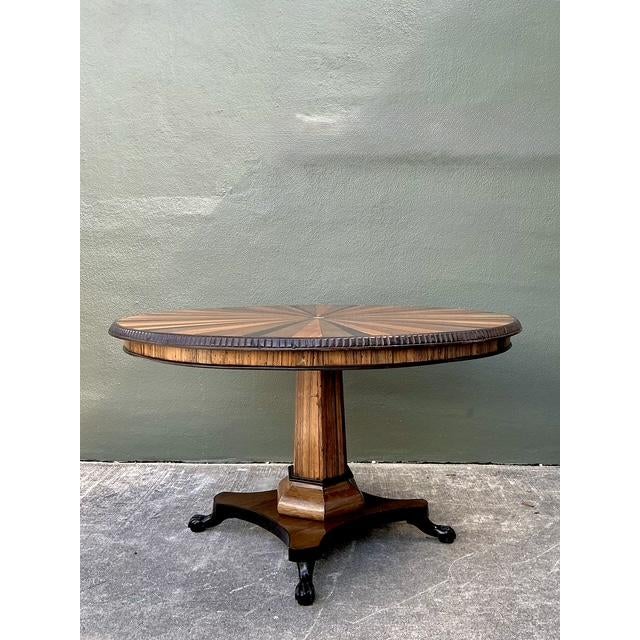 This exquisite pedestal dining table is a masterclass in marquetry, featuring a dramatic starburst inlay top that serves...