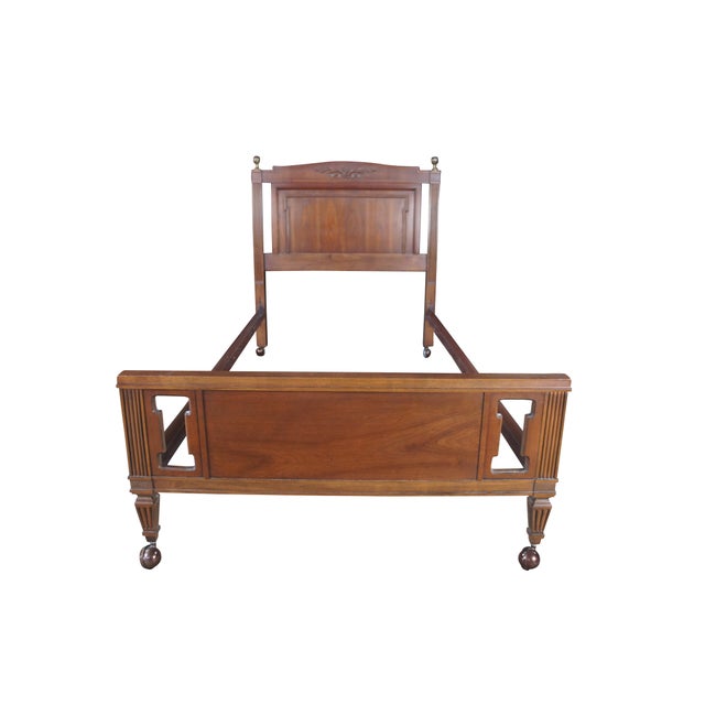 Mid Century walnut twin size bed featuring Neoclassical styling with floral and ribbon crested headboard, brass pineapple...
