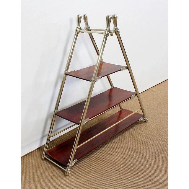 Pyramid-shaped shelf made of a chromed metal frame and three solid mahogany shelves forming a gradient. This rare model...