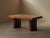 Art Deco table with a geometric marquetry top in oak and walnut, resting on two broad column-like supports joined by metal...