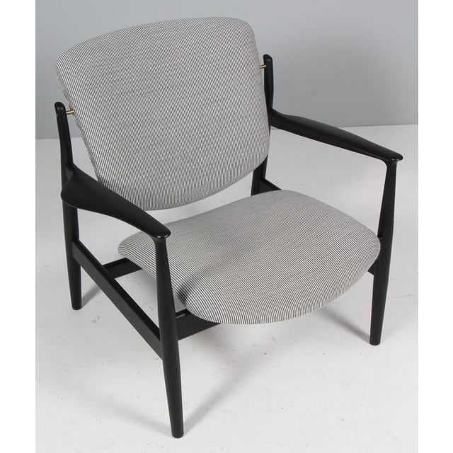 Finn Juhl lounge chair in solid black lacquered ash. Upholstered with patterned wool fabric. Model France, made by...