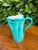 A sculptural mid-century Italian art pottery vessel featuring a vibrant turquoise glaze and distinctive organic form. The...