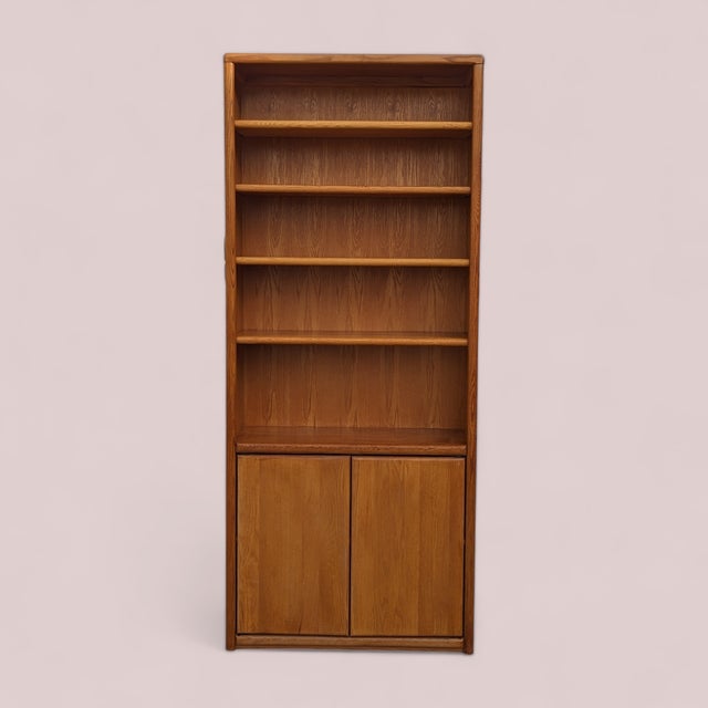 A tall vintage oak bookcase with an exceptionally useful 12.75-inch depth, adjustable open shelving and concealed storage...