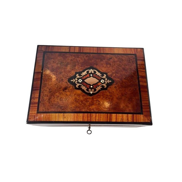 A handsome 19th century French jewelry box crafted in richly figured burl wood with contrasting wood banding and...