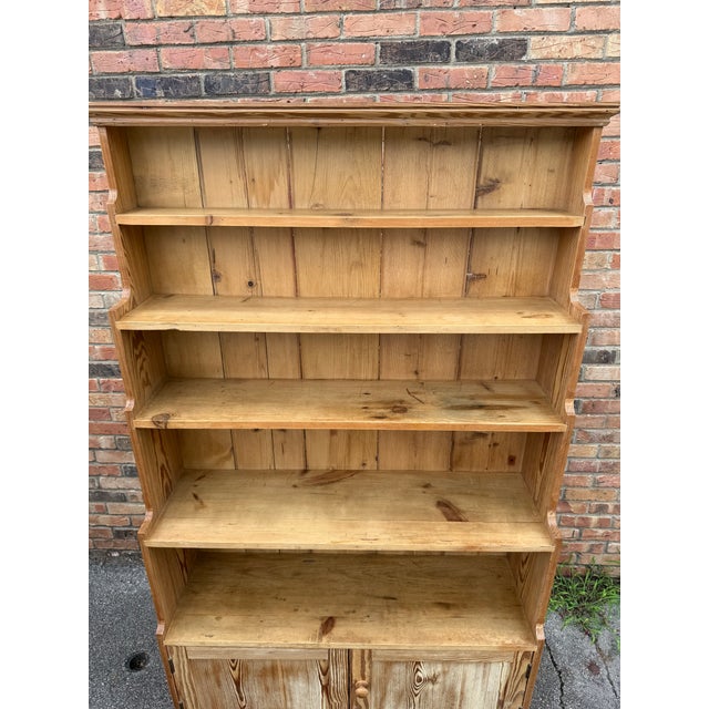 This cabinet is a classic antique pine dresser hutch, a traditional piece of farmhouse furniture often used in kitchens or...