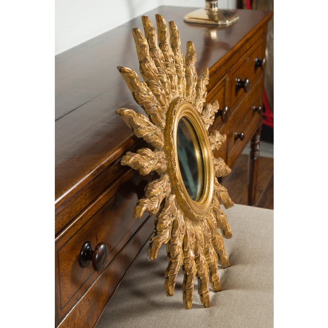 A French giltwood sunburst mirror from the mid-20th century, with wavy sunrays. Created in France during the midcentury...
