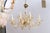 A sculptural Murano chandelier with amber glass arms, hand blown bobeche, and elegant fluted up-arms in between each of...