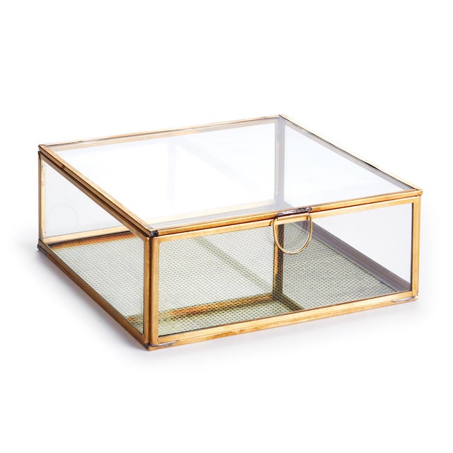 Simple and tailored, this glass and brass box is made to hold your most treasured mementos. A brass mesh layer adds a...