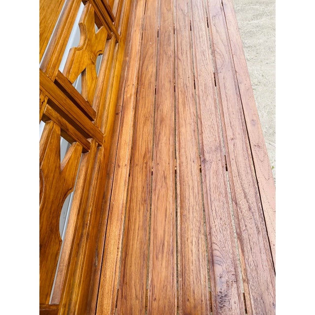 This is a late 20th century handcarved teak decorator bench. This bench has a hand carved X design to the back with a soft...