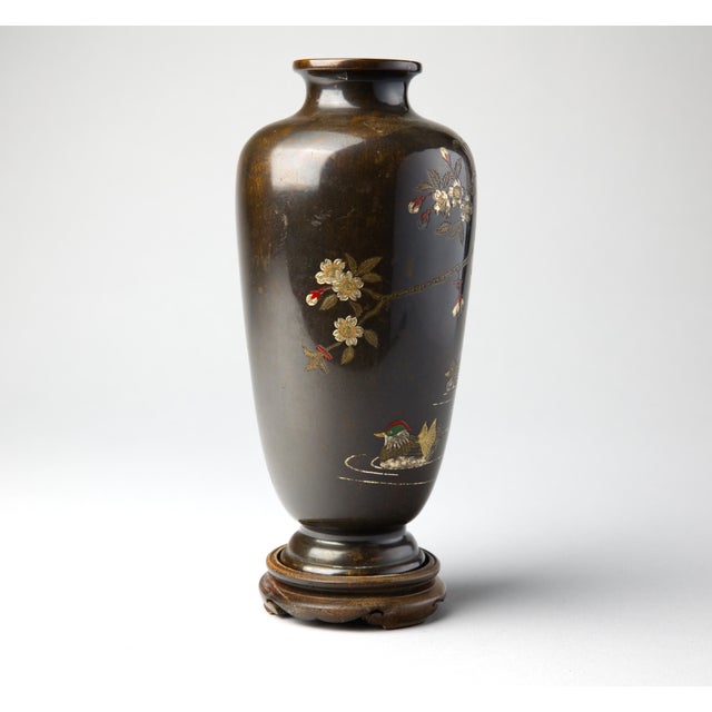 A finely decorated Japanese Meiji period bronze vase of ovoid form, presented on its original fitted carved hardwood...