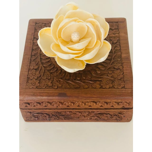 Lovely handcarved antique box of tropical wood with a beautiful sea shell flowers on top.