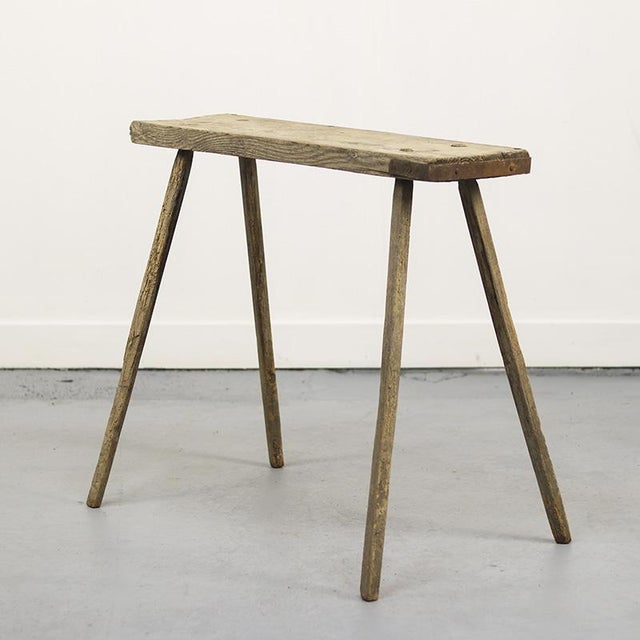 This tall, primitive pine work table, once purely functional as a piece of work furniture, has now become a strikingly...