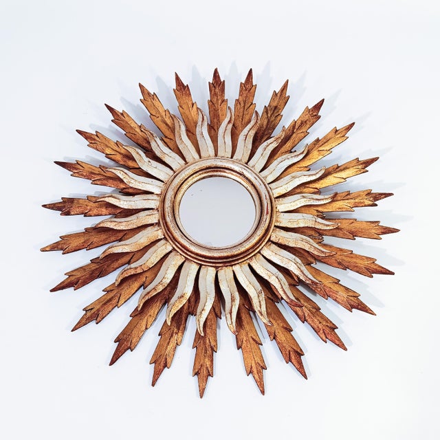 Large sun mirror in wood and gold leaf, France, 1950s. Body formed by two concentric crowns of handmade wooden rays: a...