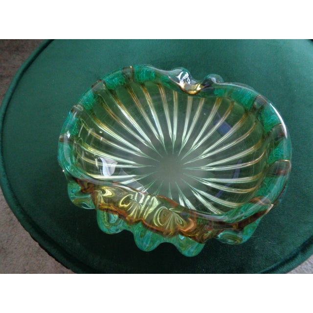 This hand blown image features a shell-like or ruffled design and incorporates a unique color palette such as green and...