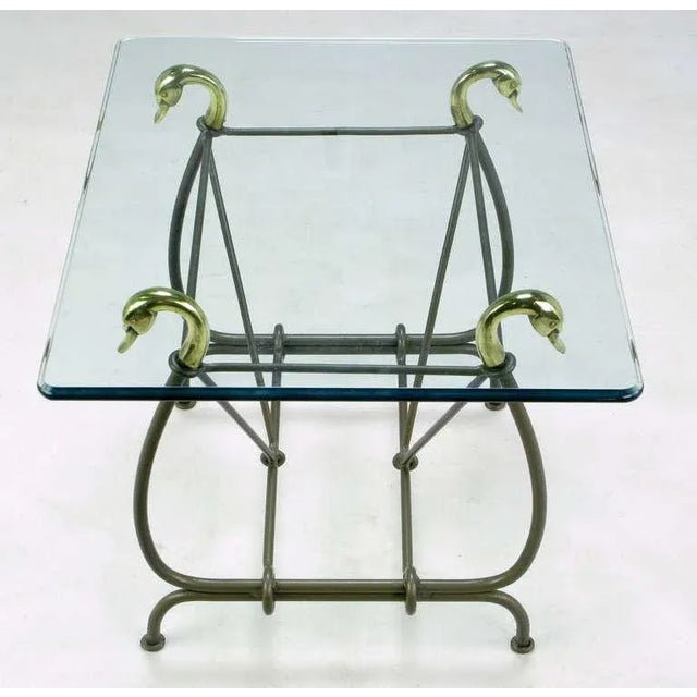 Wrought iron side table with cast brass swan heads as glass supports and lacquered in gun metal grey. Lyre-form frame is...