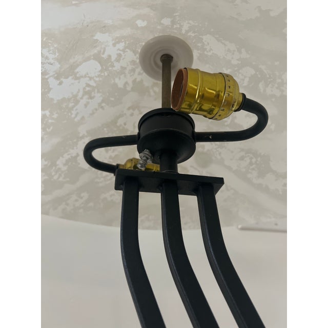 Striking postmodern floor lamp features a sculptural wavy black metal stem rising from a substantial rectangular base and...