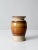 This is a vintage studio pottery vase. The hand-crafted ceramic vase is cream with a brown ombre swirled central glaze...