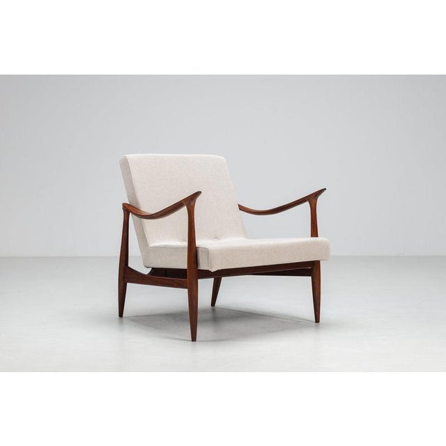 A beautifully sculptural Danish lounge chair from the 1960s, featuring a refined teak frame and distinctive organic lines....