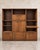 A substantial vintage three-piece modular wood bookcase made from three horizontal units that stack into one architectural...