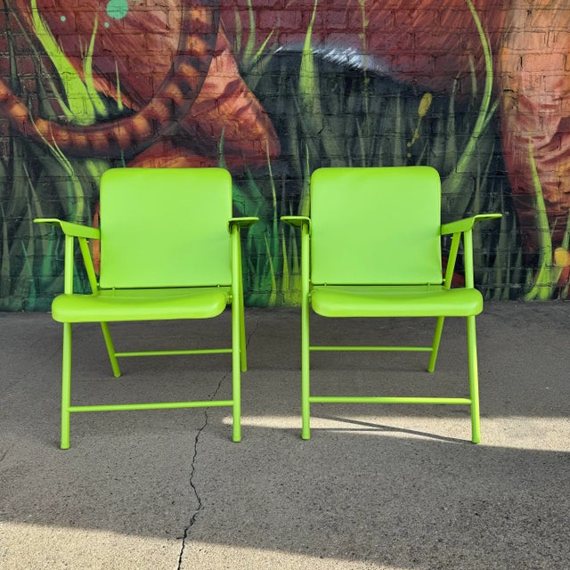 Pair of metal folding chairs by Russell Wright, freshly powder coated in a funky and eccentric bright green. These chairs...