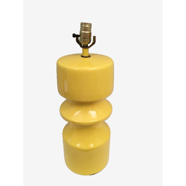 A 1980's bright yellow glazed ceramic table lamp with a shapely hooped design. The finial and shade are not included in...