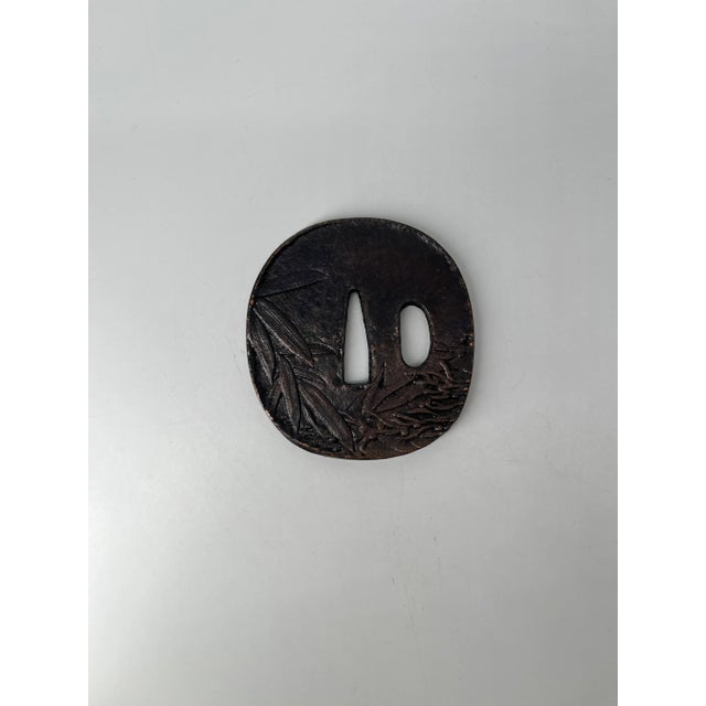 An authentic antique Japanese samurai sword hilt (tsuka) crafted from iron and beautifully engraved with traditional...