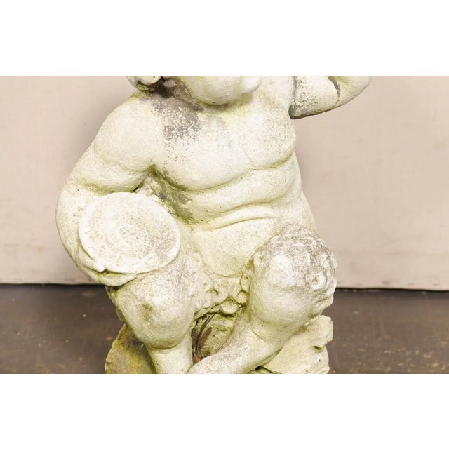 A French faun garden ornament from the mid 20th century. This mid-century cast-stone statue from France depicts a young,...