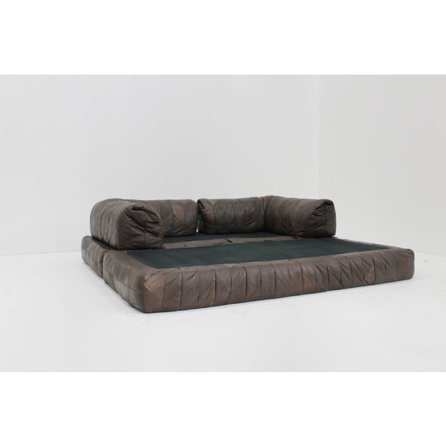Vintage 1970s leather patchwork sofa with a bold, sculptural design. This two-seat piece features richly aged leather,...