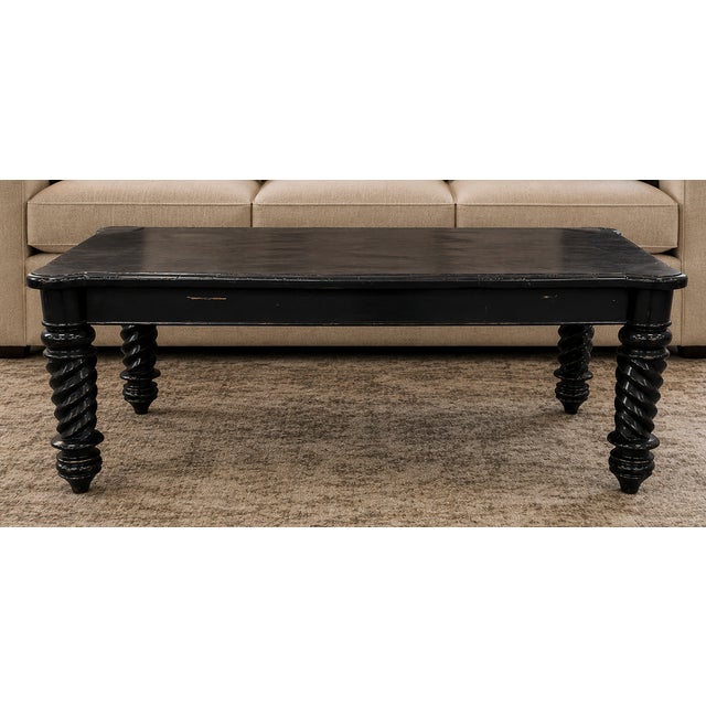 The table features a rectangular top with rounded corners and four distinctive, elaborately turned legs with a spiral or...