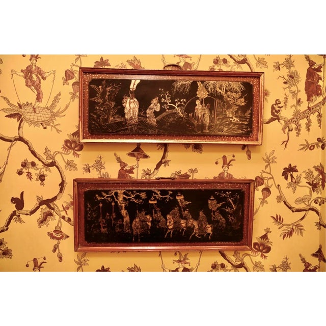 A pair of antique Chinese lacquered wall mounted panels with gilt decoration in a molded red wood frame with a speckled...