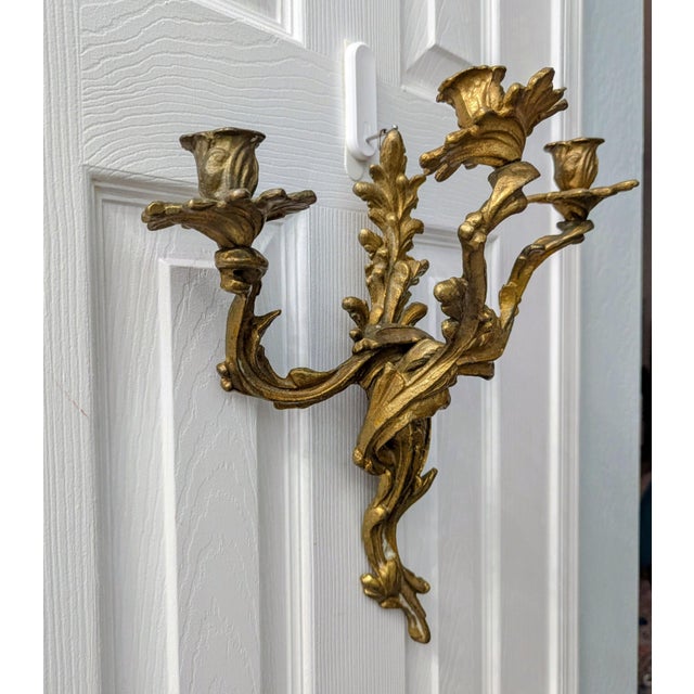 These are a pair of antique Rococo style solid brass three-arm candle wall sconces. They are likely from the 1920s and...