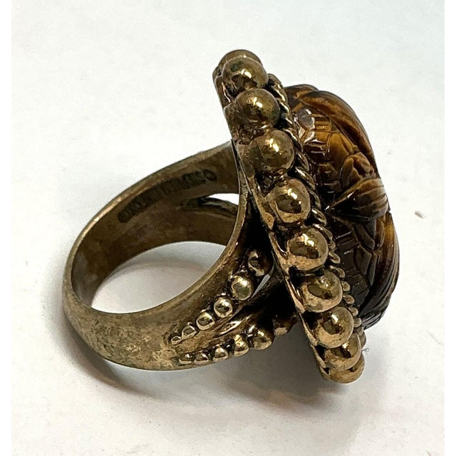 Stephen Dweck Ring. A beautifully floral-carved cabochon tiger's eye. Sterling Silver with a bronze patina. Rope twist...
