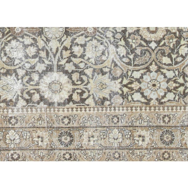 This Antique Persian Tabriz Rug, sized 7'3" x 9'10", is handwoven in Northern Iran’s Tabriz region. Distressed and...