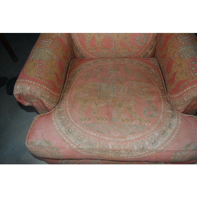 This vintage chair is in good shape overall. A pale orange with an asian look / elephant. Comfortable with a deep cushion...