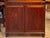 This English mahogany waterfall bookcase has a shaped crest rail above two open shelves, over a lower cabinet fitted with...