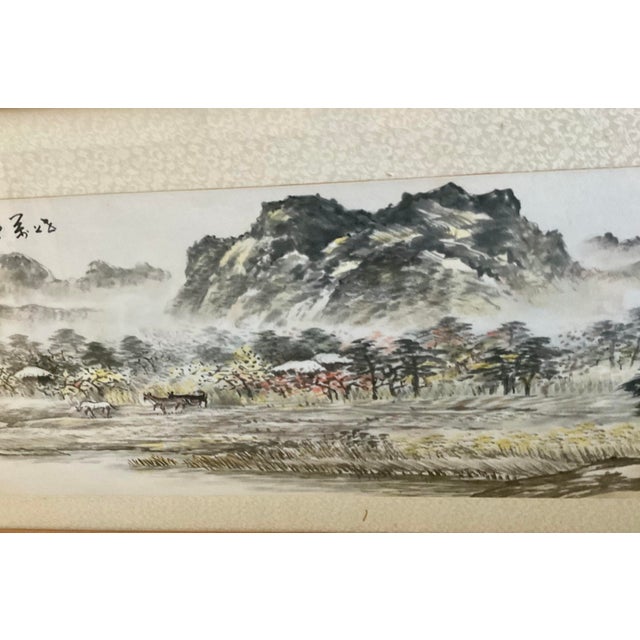 Beautiful vintage Chinese ink wash landscape painting presented in a wood frame behind glass. The panoramic composition...
