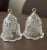 Two Mikasa Christmas bells. Embossed and frosted. Each with a different scene. One bell has angles and deer with Christmas...