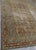 Distressed antique hand-knotted Persian Kerman decorative rug featuring a beige center field, ornate floral motifs, and a...