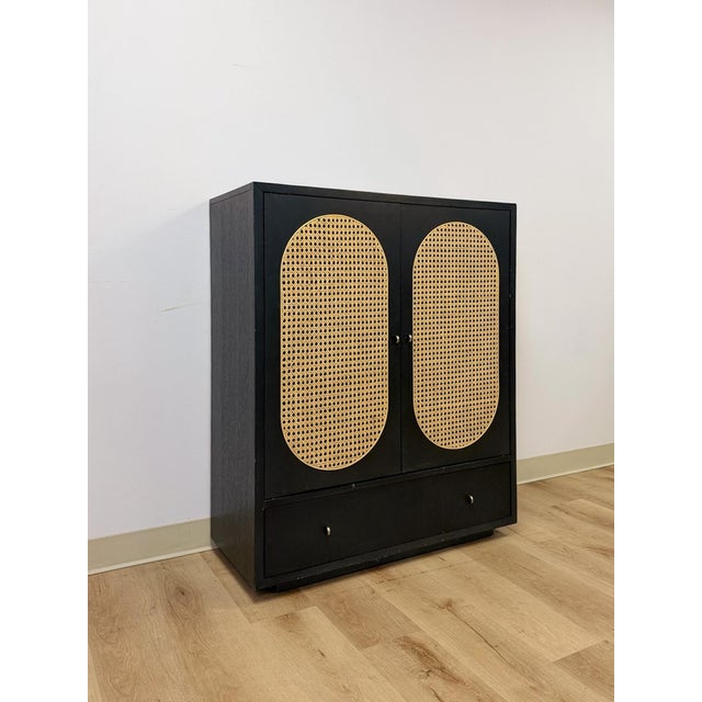 This modern tallboy cabinet from Bobby Berk's furniture collection combines a sleek satin black finish with striking beige...