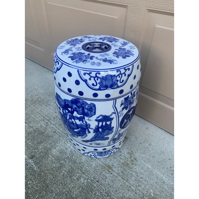 A classic blue and white porcelain garden stool, decorated with traditional Chinese scenes and motifs and stylized floral...