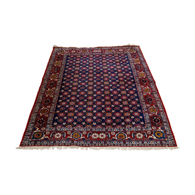 The meticulously handmade Persian Tabriz woolen rug, dating back to the 1920s, exhibits a striking, classical floral...
